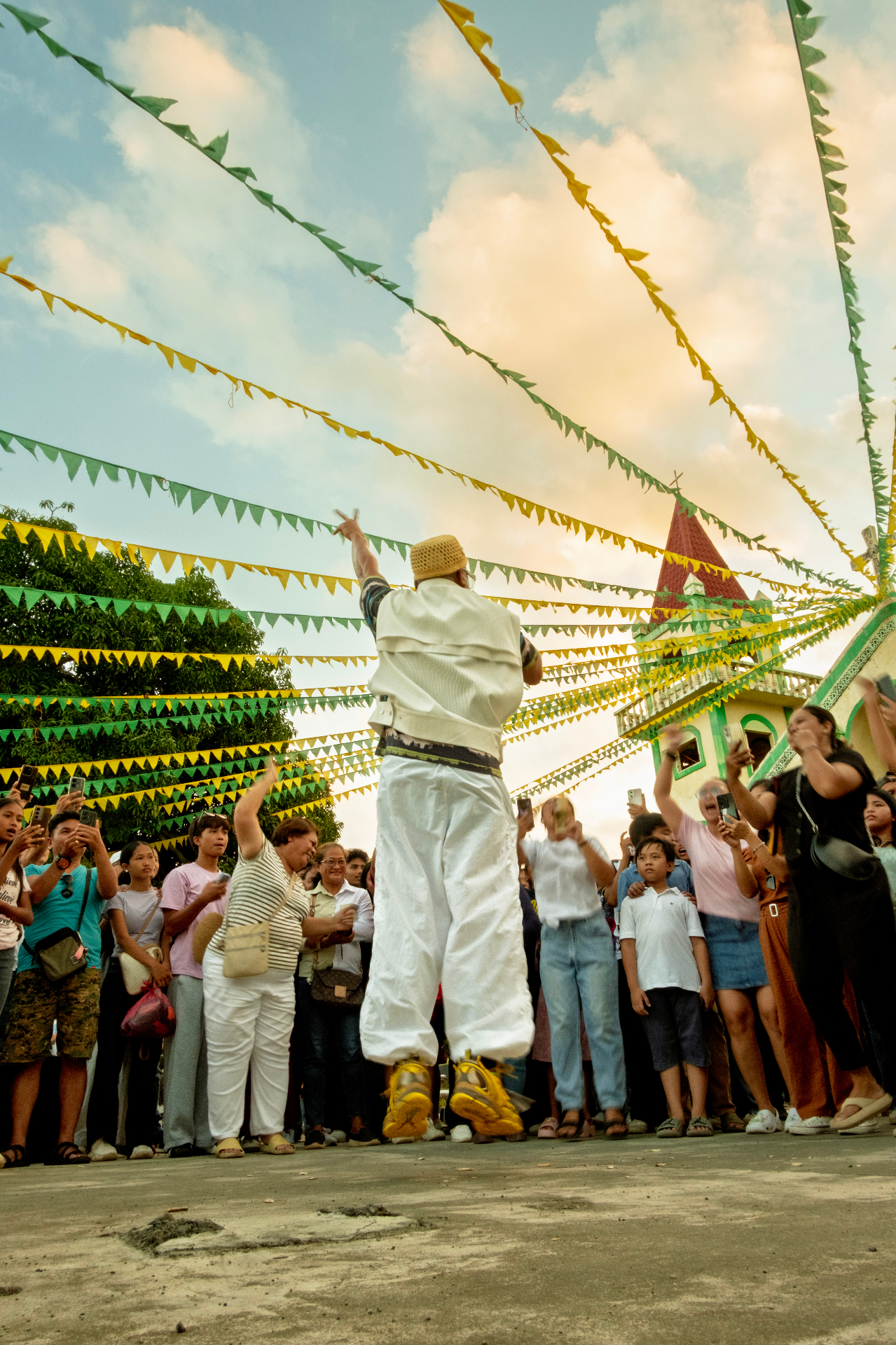 A community fiesta - bunting overhead, a figure mid-jump in celebration.